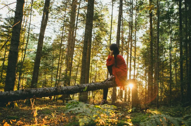 woman on a log in a forest